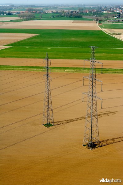 Hoogspanningslijnen in een grootschalig landbouwgebied